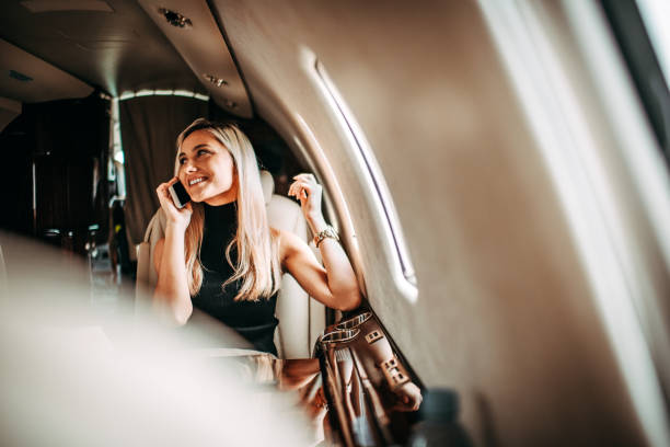 istock Young businesswoman having a conversation on a smart phone while flying in a private jet 1077090496