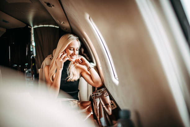 istock Young blonde businesswoman having a conversation on a smart phone while flying in a private jet 1077090672