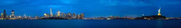 Panorama of New york city and liberty statue in blue night twilight time.