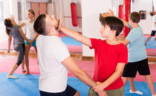 istock Kids exercising self-defense movements 1077091122