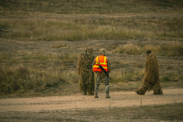 Soldiers in camouflaged sniper suit searching for the position