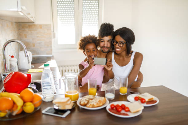 istock Young happy family having breakfast at home 1077091450