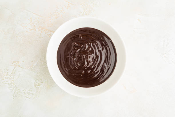 istock Melted chocolate, cream, ganache in white ceramic bowl, top view 1077092934