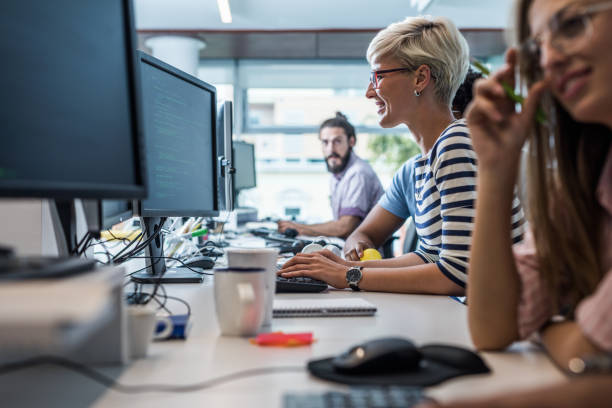 istock Happy female programmer working on desktop PC in the office. 1077093890