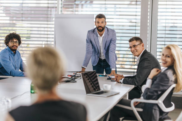 istock Male CEO communicating with his colleagues during a presentation in a board room. 1077094004