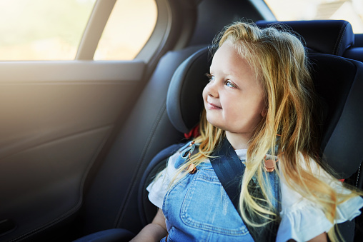 Shot of an adorable little girl sitting in her carseat while driving