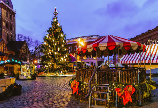 Carousel at Christmas market on Dome Square with Xmas tree and stalls in Riga in Latvia in winter. Eraly in the morning