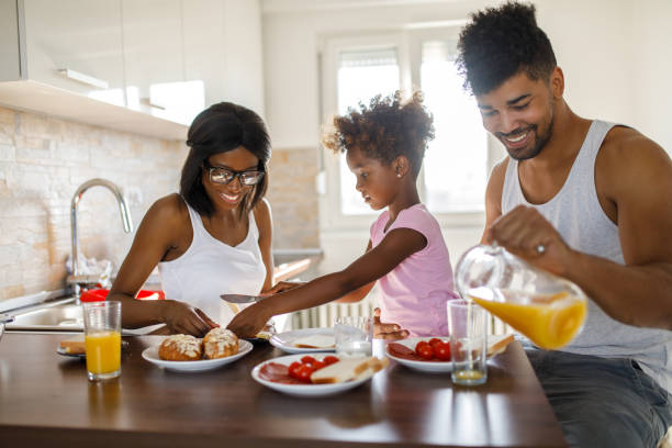 istock Young happy family having breakfast at home 1077099540