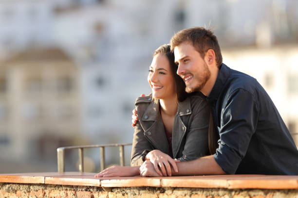 istock Happy couple contemplating views from a balcony at sunset 1077099634