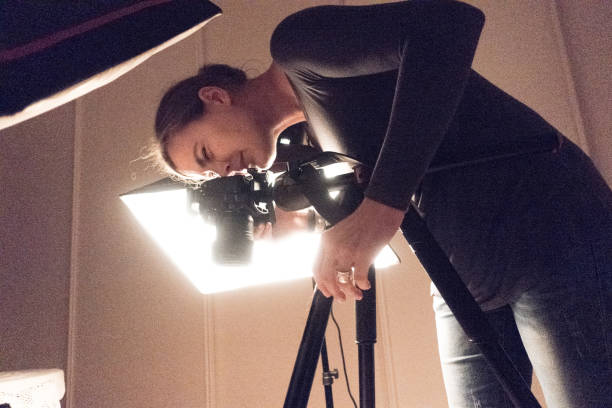 Young Female Photographer Using DSLR Camera in Photo Studio stock photo
