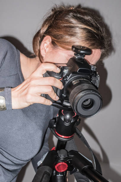 istock Young Female Photographer Using DSLR Camera in Photo Studio 1077100094