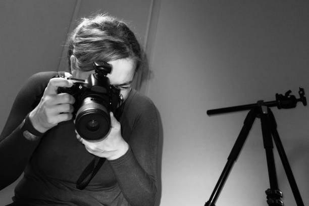 istock Young Female Photographer Using DSLR Camera in Photo Studio 1077100096