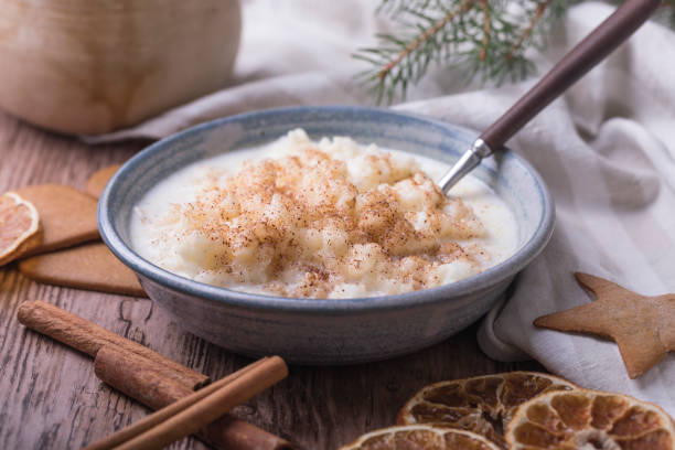 Traditional rice pudding Traditional rice pudding also known as tomtegröt or swedish risgrynsgröt. The rice pudding is in a blue ceramic bowl on a wooden table, with gingerbread cookies, cinnamon and dried orange slices around the bowl. porridge stock pictures, royalty-free photos & images