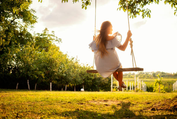 istock Beautiful woman enjoying on a swing 1077102282