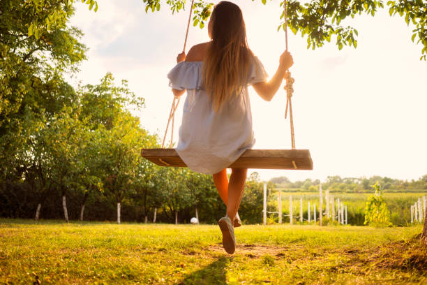 istock Beautiful woman enjoying on a swing 1077102434