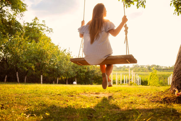 istock Beautiful woman enjoying on a swing 1077102438