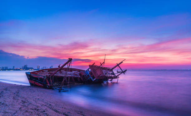 istock Long exposure  the old shipwreck have abandoned on beach with colorful twilight sky at sunset time 1077105302