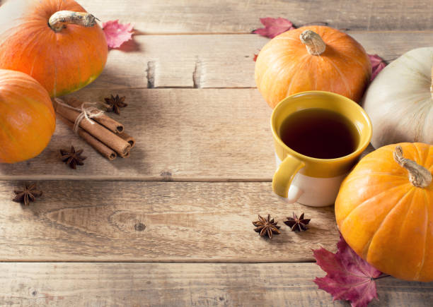 istock Cup of tea with pumpkins and cinnamon over wood texture 1077110514