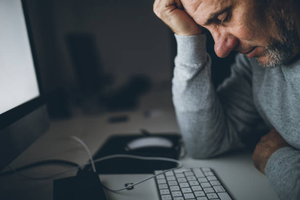 istock Serious man tired from working late 1077113834