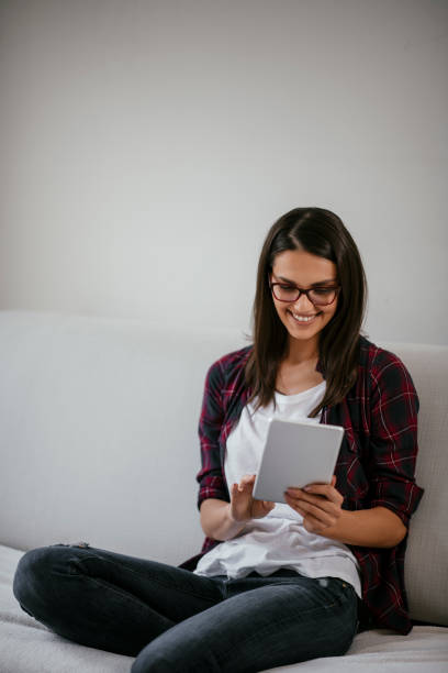 istock Beautiful woman using tablet in her living room 1077119418