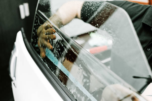 istock Man applying window film on a car window 1077122098