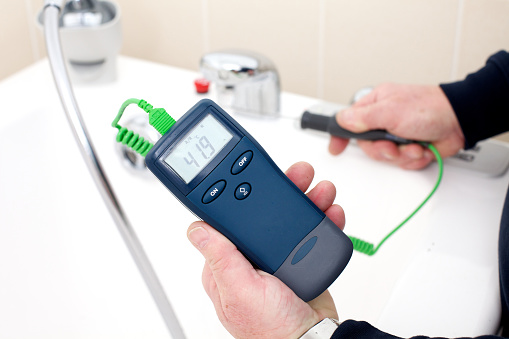 Using a digital thermometer with probe to measure the tempreture of hot tap water