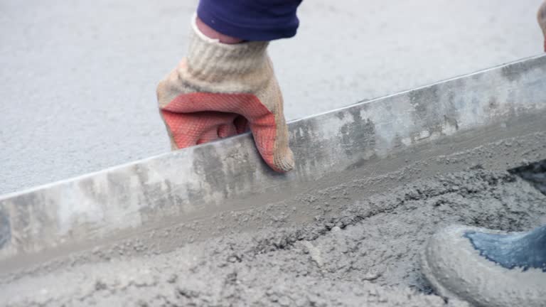 Leveling the fresh concrete with a long leveling tool