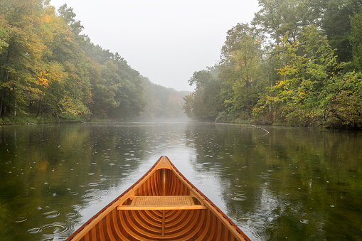 Cedar canoe on a river during a light rain