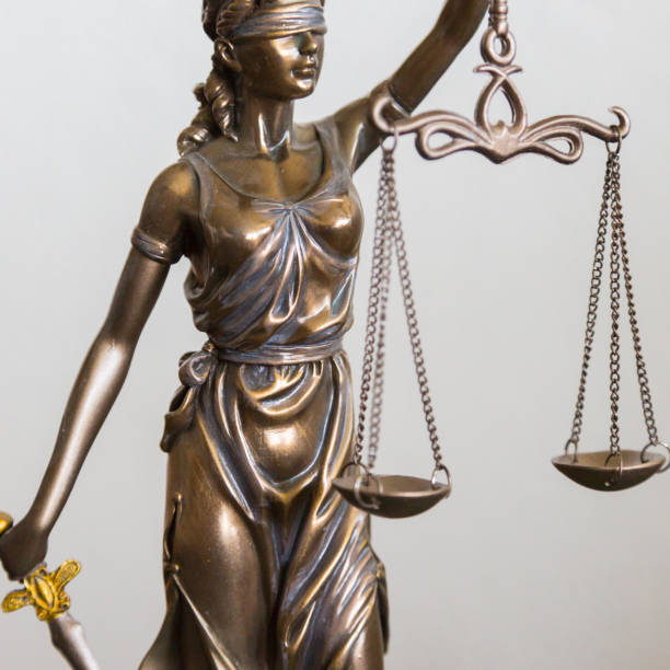 istock portrait Justitia figure with blindfold, sword and balance 1077133320