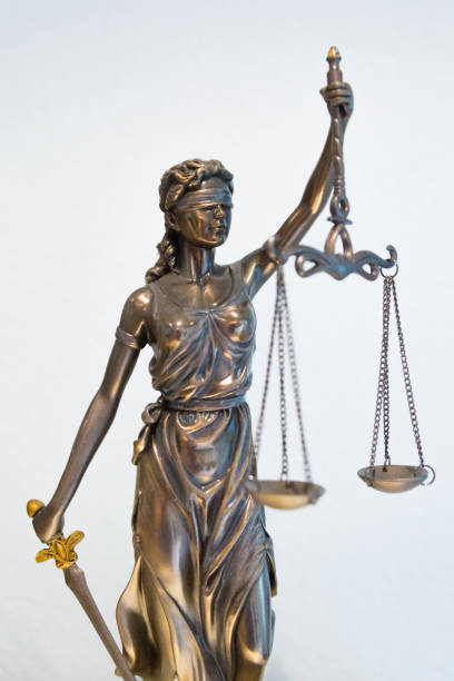 istock Justitia figure with blindfold, sword and balance 1077133358