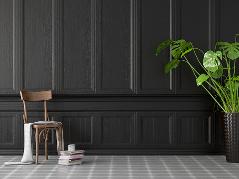 Empty black wooden wall panel with vase and plant