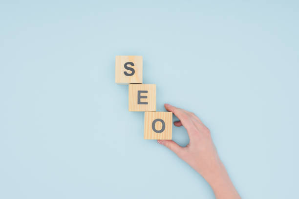istock Top view of female seo manager holding cube on light blue background 1077139688