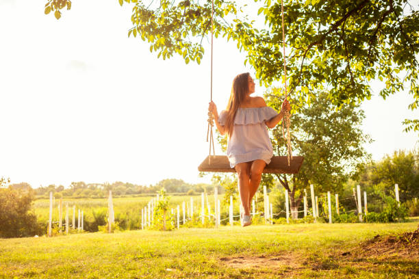 istock Beautiful woman enjoying on a swing 1077142322