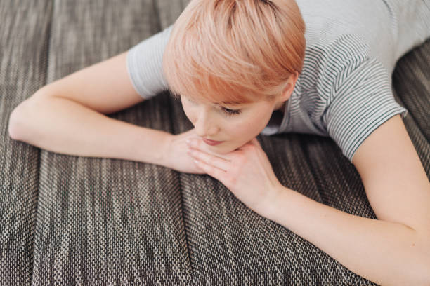 istock Young woman relaxing on a couch thinking 1077142752