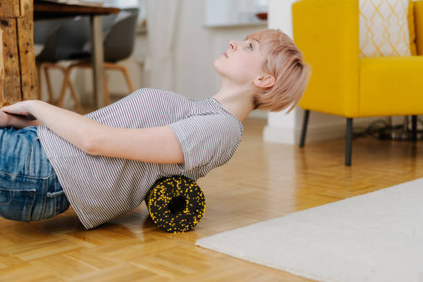 istock Woman exercising her back with foam roller 1077144532