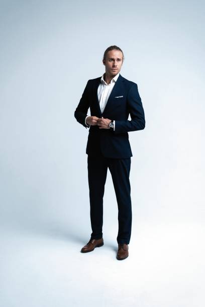 istock Perfect suit. Full length of handsome young man in suit looking at camera while standing against white background 1077146052