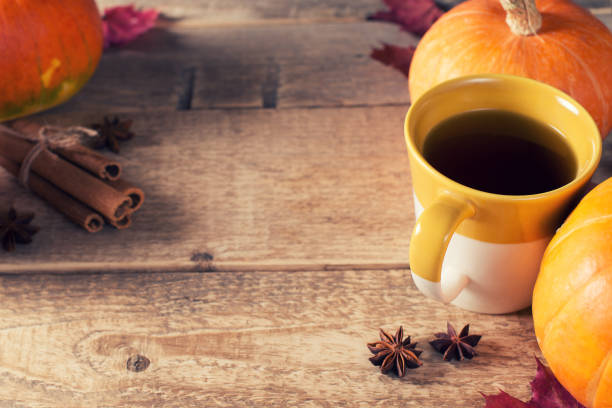 istock Cup of tea with pumpkins and cinnamon over wood texture 1077146094