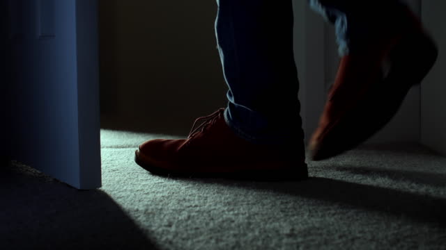 Leaving a dark room, close up of man's feet. DS.