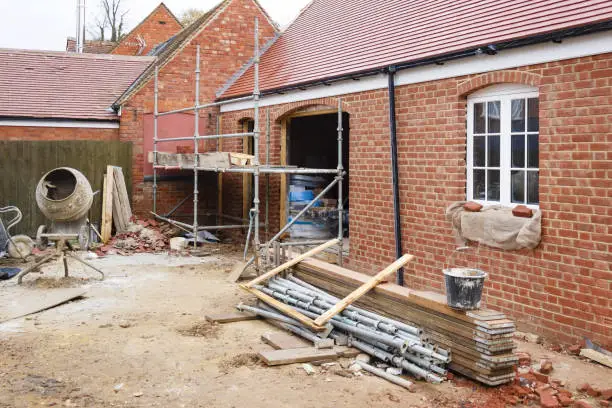 Building site in UK with brick house extension under construction