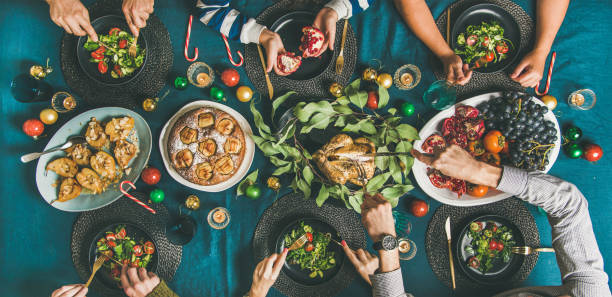 Human hands eating different meals at Christmas party dinner
