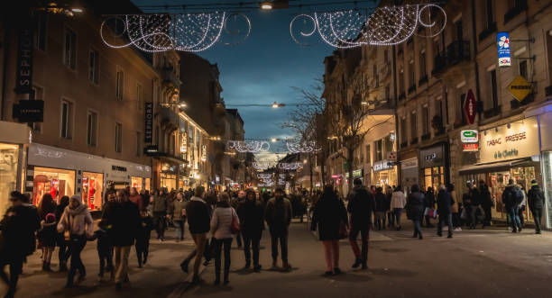 歩行者は、ベルフォールの商店街夜の散歩温かみのある服を着てください。 - city of nice night france snow ストックフォトと画像