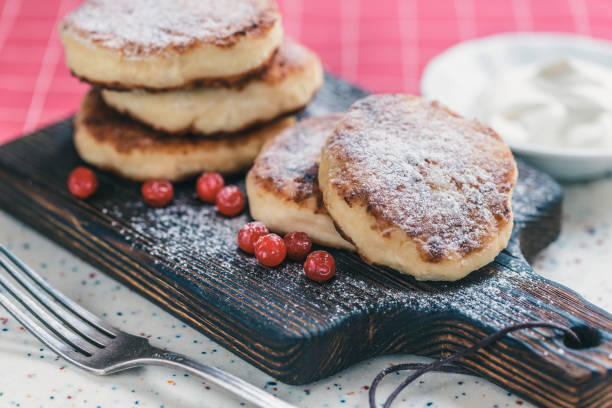istock On a white table made of artificial stone is a plate with five cottage cheese pancakes and red berries. 1077154070