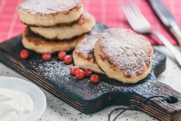 istock On a white table made of artificial stone is a plate with five cottage cheese pancakes and red berries. 1077154280