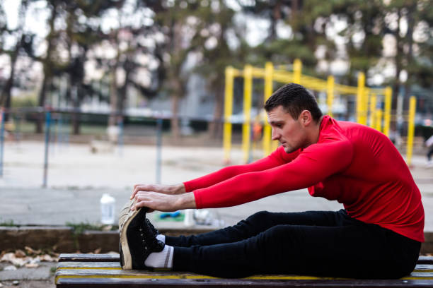 istock Sportsman stretches legs after exercise 1077154286