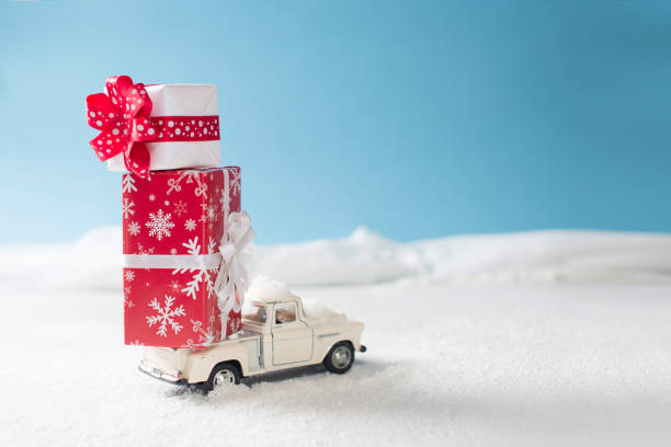 istock Crhistmas card with toy car and red gift boxes on snow 1077154298