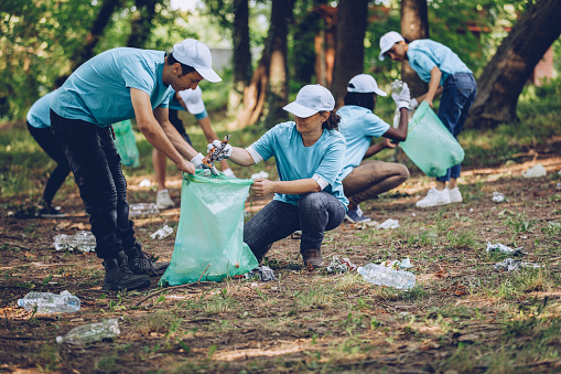 Group of people, cleaning together in public park, saving the environment.