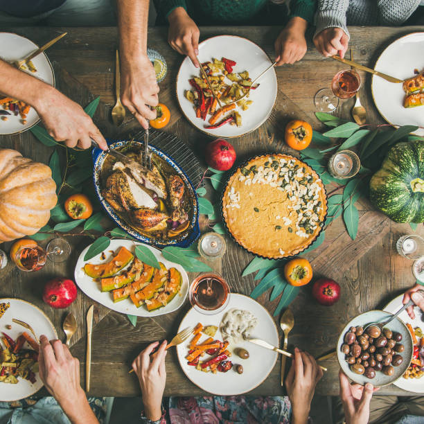 istock Friends feasting at Thanksgiving Day table with turkey, square crop 1077156696
