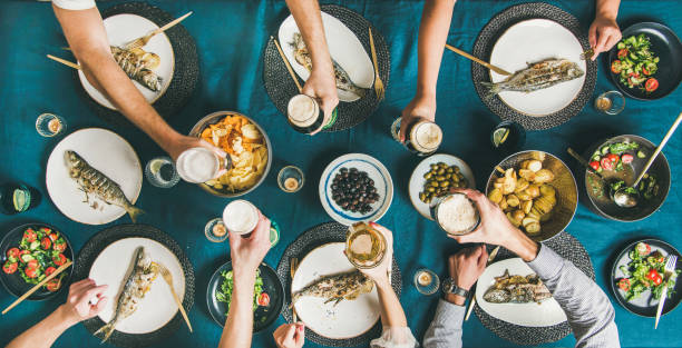 istock Friends eating fish and chips and drinking beer together 1077158160