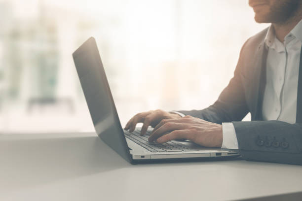 istock young man typing on laptop in modern bright coworking office 1077159760