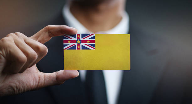 istock Businessman Holding Card Niue Flag 1077159948